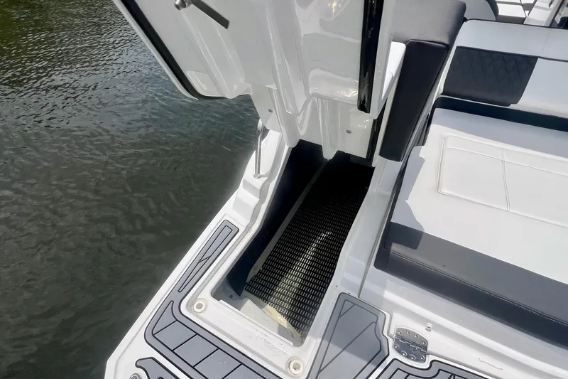 Slide: The Image of 2024 Monterey M-45 boat interior with open storage compartment, sleek seating, and water view. - 22