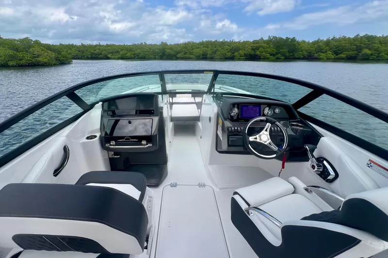 Slide: The Image of 2024 Monterey M-45 boat interior with sleek dashboard and steering, on a serene lake. - 7