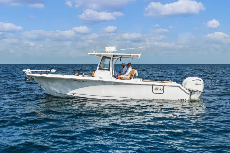Slide: The Image of 2022 Sea Hunt Gamefish 30 boat cruising on open water under a blue sky. - 2