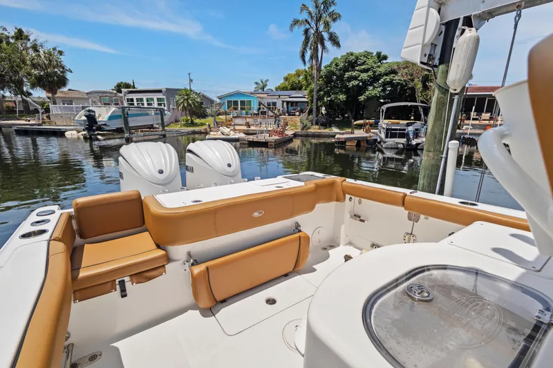 Slide: The Image of 2022 Sea Hunt Gamefish 30 boat with forward seating, docked in a scenic marina. - 22