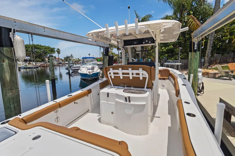 Slide: The Image of 2022 Sea Hunt Gamefish 30 boat with forward seating, docked in a scenic marina. - 23