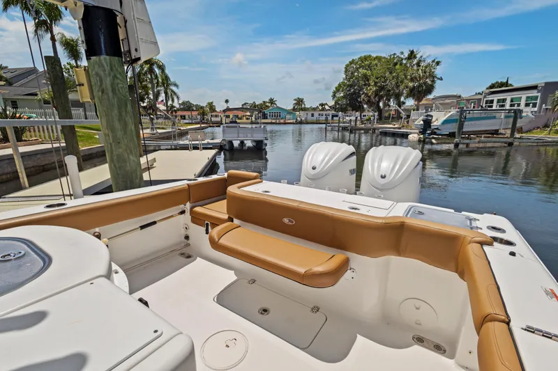 Slide: The Image of 2022 Sea Hunt Gamefish 30 boat with forward seating, docked in a scenic marina. - 25