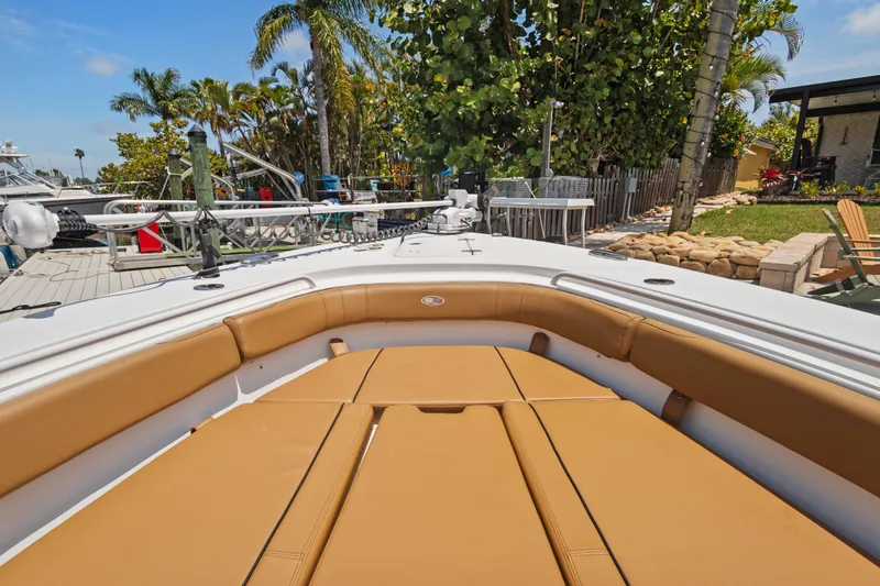 Slide: The Image of 2022 Sea Hunt Gamefish 30 Forward Seating boat with tan cushions, docked near palm trees. - 31