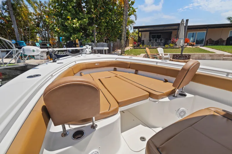 Slide: The Image of 2022 Sea Hunt Gamefish 30 boat with forward seating, docked near a modern house. - 32