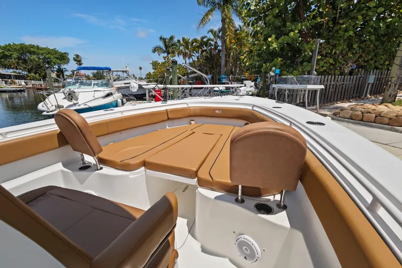 Slide: The Image of 2022 Sea Hunt Gamefish 30 Forward Seating boat with tan cushions docked near palm trees. - 33