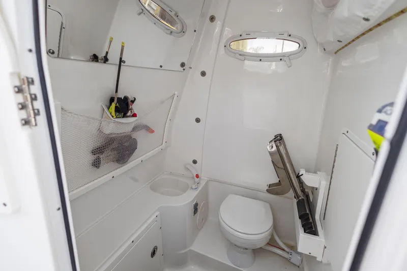 Slide: The Image of Interior of 2022 Sea Hunt Gamefish 30 boat bathroom with toilet and storage. - 48