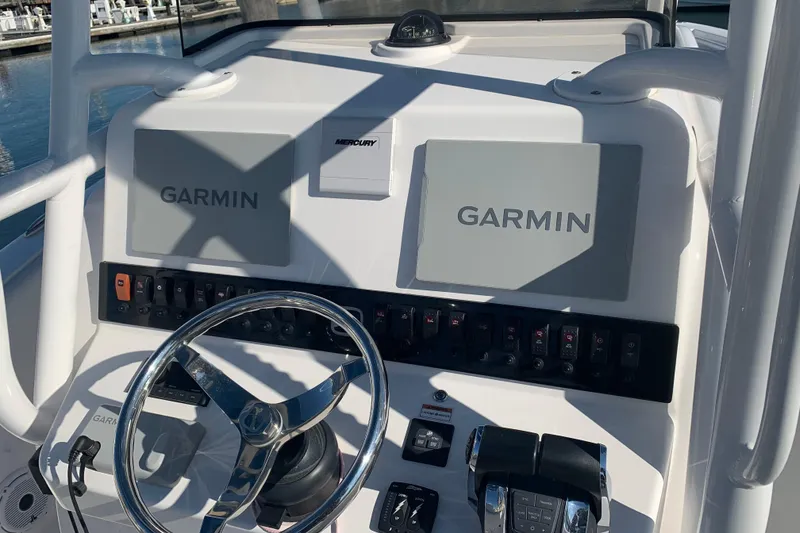 Slide: The Image of 2020 Belzona 27 CC boat dashboard with Garmin displays and Mercury controls. - 19