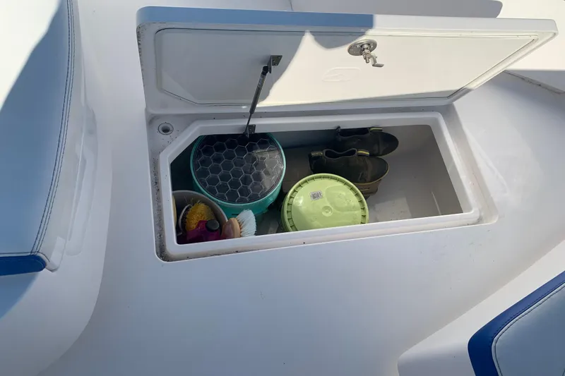 Slide: The Image of Storage compartment on a 2020 Belzona 27 CC boat with cleaning supplies and boots. - 22