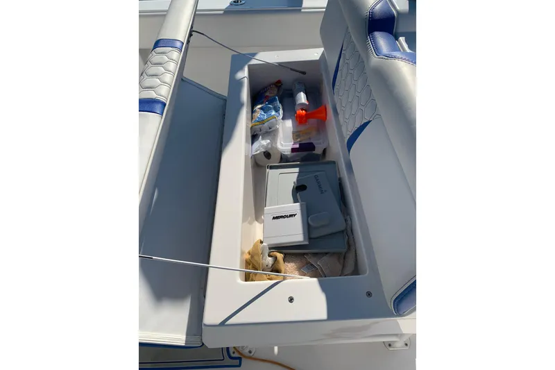 Slide: The Image of Storage compartment on a 2020 Belzona 27 CC boat with various items inside. - 24