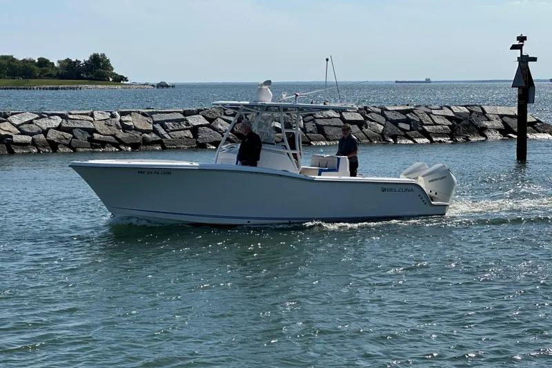 Slide: The Image of 2020 Belzona 27 CC boat cruising near rocky shoreline on a sunny day. - 3