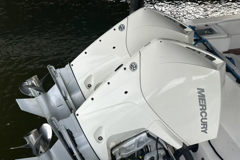 Slide: The Image of Twin Mercury outboard engines on a 2020 Belzona 27 CC boat, docked on water. - 13
