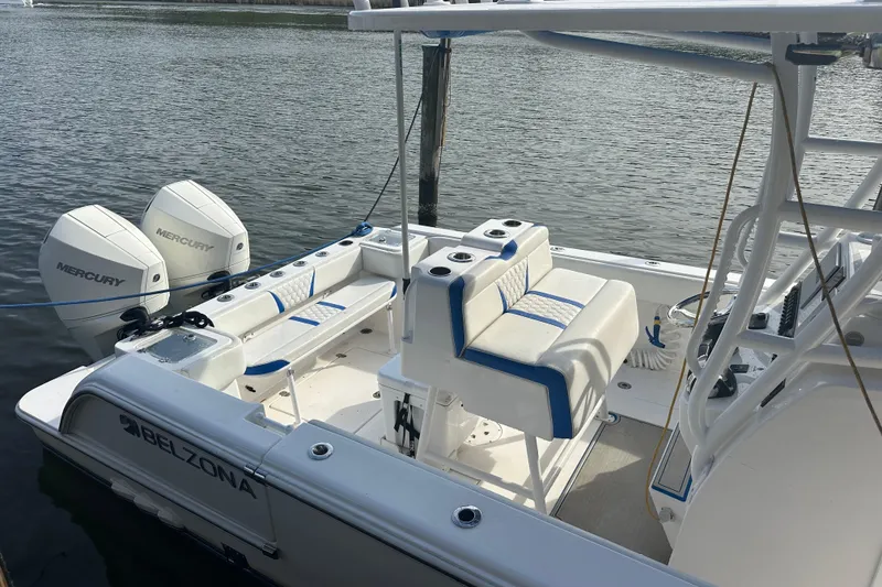 Slide: The Image of 2020 Belzona 27 CC boat with dual Mercury engines, docked on calm water. - 6