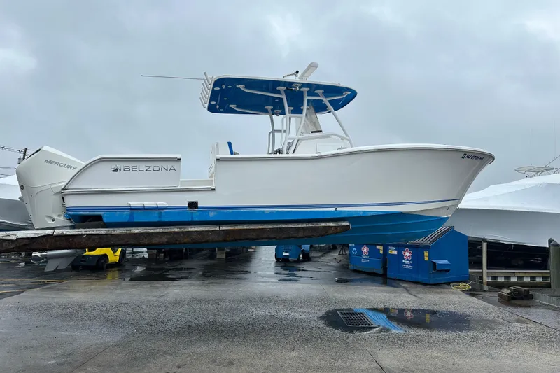 Slide: The Image of 2020 Belzona 27 CC boat on a lift, featuring a sleek white and blue design. - 10