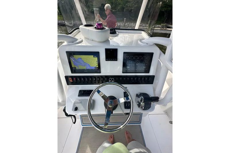 Slide: The Image of 2020 Belzona 27 CC boat dashboard with navigation screens and steering wheel. - 23