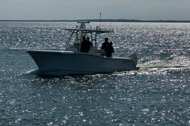 Slide: The Image of 2020 Belzona 27 CC boat cruising on shimmering water under clear skies. - 4