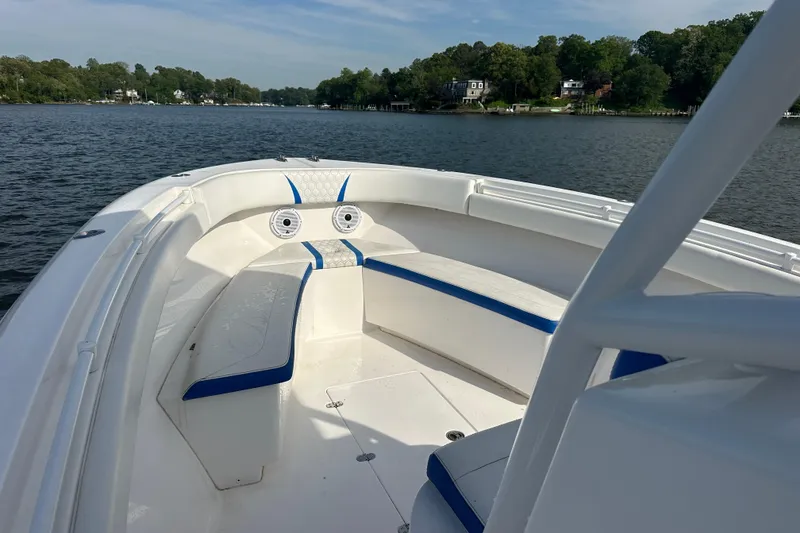 Slide: The Image of 2020 Belzona 27 CC boat interior with white and blue seating on a calm lake. - 17