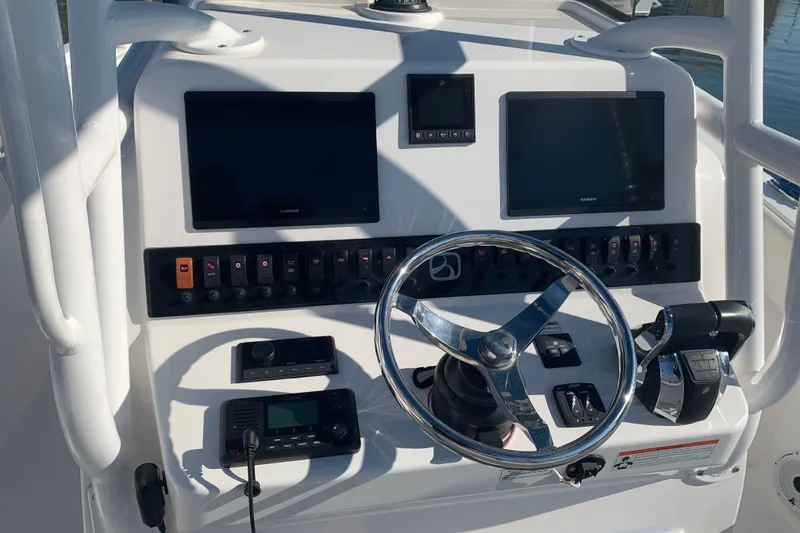 Slide: The Image of 2020 Belzona 27 CC boat dashboard with steering wheel and electronic controls. - 18