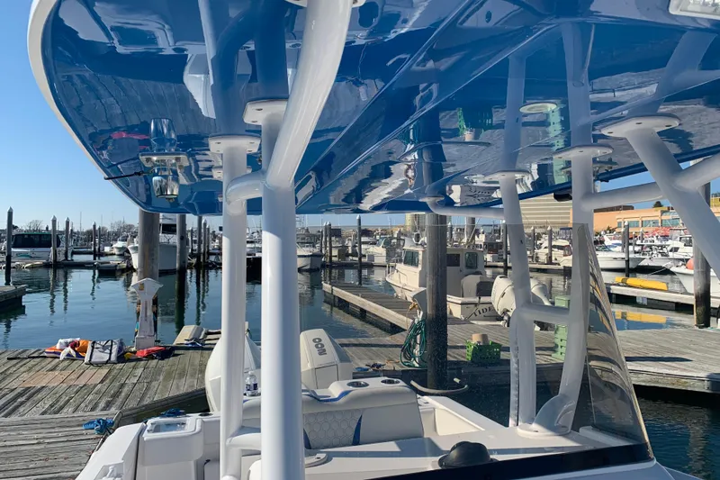 Slide: The Image of 2020 Belzona 27 CC boat docked at a marina with blue canopy. - 7