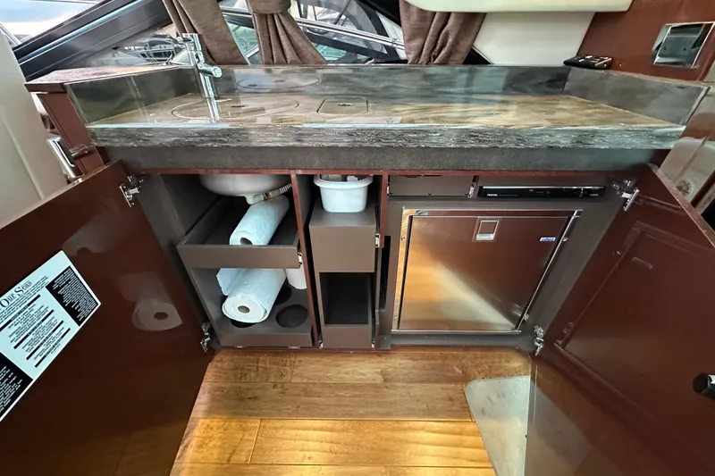 Slide: The Image of 2014 Sea Ray Sundancer 510 yacht kitchen with sink, storage, and stainless steel appliances. - 11