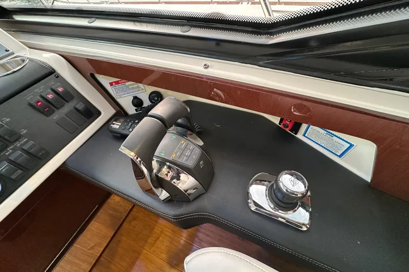 Slide: The Image of 2014 Sea Ray Sundancer 510 helm controls with joystick and throttle levers. - 14