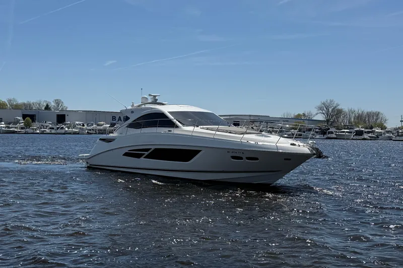 Slide: The Image of 2014 Sea Ray Sundancer 510 yacht cruising on a sunny day near a marina. - 37