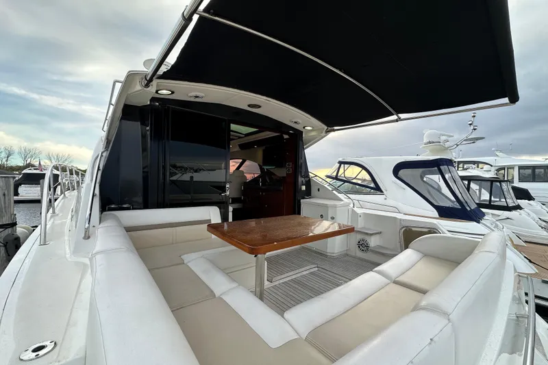 Slide: The Image of 2014 Sea Ray Sundancer 510 yacht with spacious seating and wooden table on deck. - 4