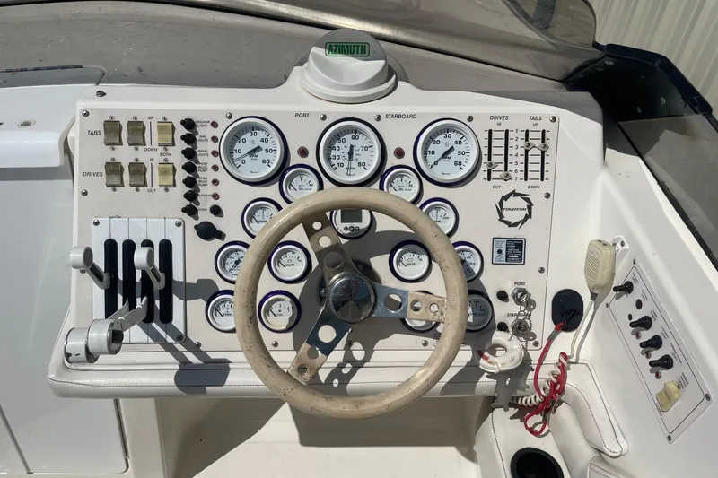 Slide: The Image of 1998 Fountain 29 Fever boat dashboard with gauges, steering wheel, and controls. - 20
