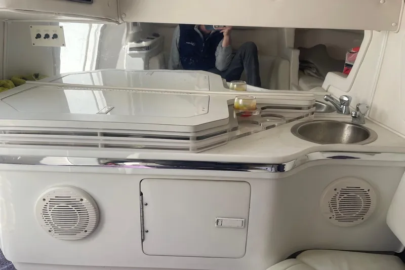 Slide: The Image of Interior of a 1998 Fountain 29 Fever boat featuring a compact kitchenette with sink and storage. - 27