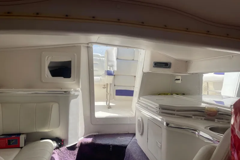 Slide: The Image of Interior of 1998 Fountain 29 Fever boat with white seating and compact kitchenette. - 28