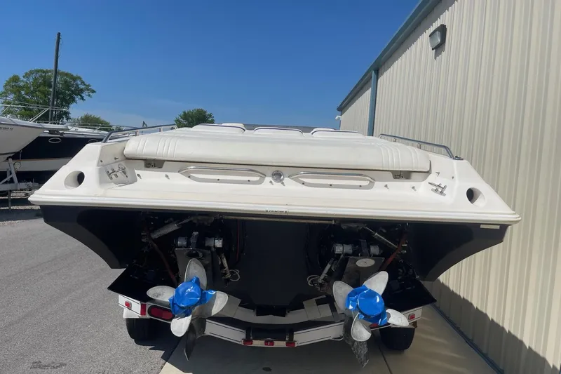 Slide: The Image of 1998 Fountain 29 Fever boat rear view with dual propellers, parked outdoors. - 3