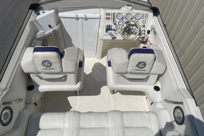 Slide: The Image of 1998 Fountain 29 Fever boat interior with white and purple seating, dashboard, and steering wheel. - 7
