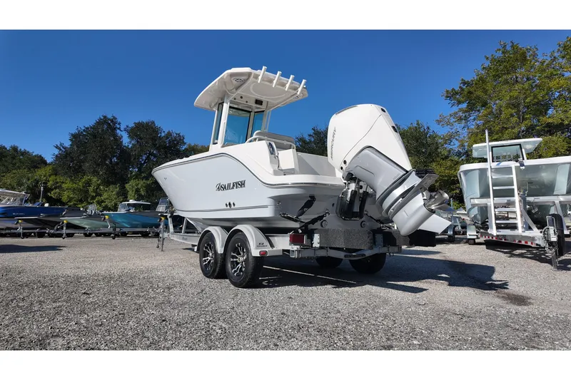 Slide: The Image of 2026 Sailfish 232 CC boat on trailer, parked outdoors under clear blue sky. - 2