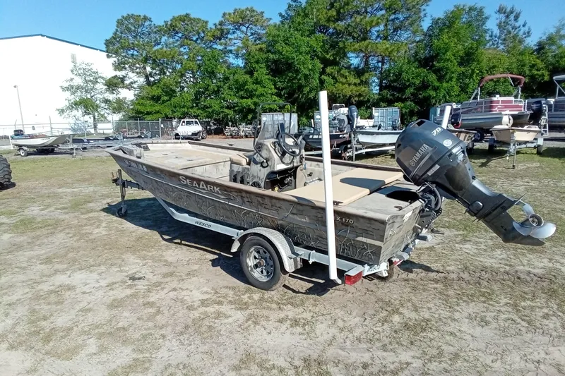 Slide: The Image of 2015 SeaArk 170 RX boat on trailer with Yamaha outboard motor, parked outdoors. - 11