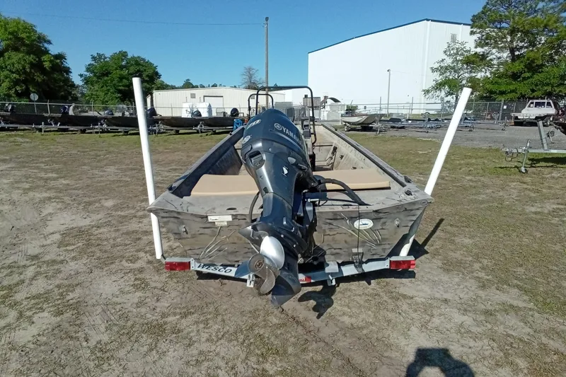 Slide: The Image of 2015 SeaArk 170 RX boat with outboard motor on trailer, parked outdoors. - 12