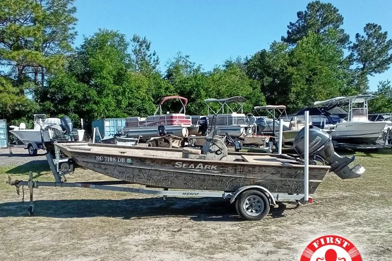 The Image of 2015 SeaArk 170 RX boat on trailer, surrounded by trees and other boats. - 4
