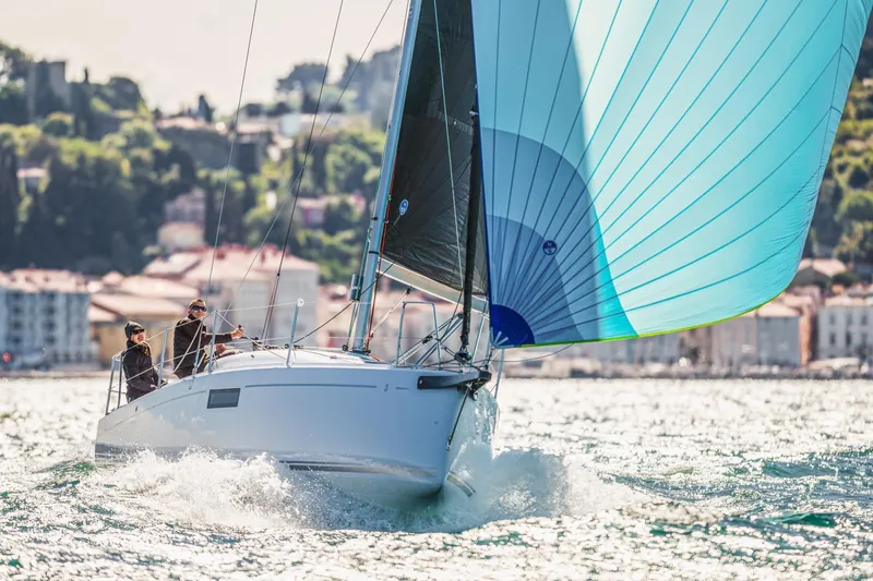 Slide: The Image of 2026 Beneteau First 30 sailboat gliding on water with vibrant blue spinnaker. - 11
