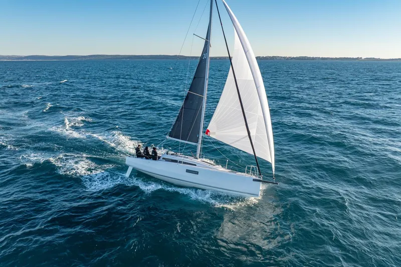 Slide: The Image of 2027 Beneteau First 30 sailboat on open sea. - 2