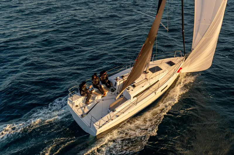 Slide: The Image of 2026 Beneteau First 30 sailboat navigating ocean waters with crew onboard. - 6