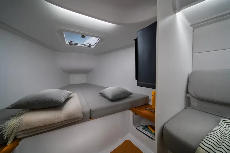 Slide: The Image of Cozy cabin interior of 2026 Beneteau First 30 sailboat with modern furnishings and skylight. - 8