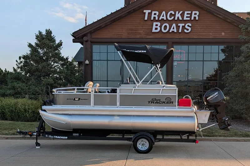 The Image of 2026 Sun Tracker Bass Buggy 16 XL Select pontoon boat outside Tracker Boats showroom. - 0
