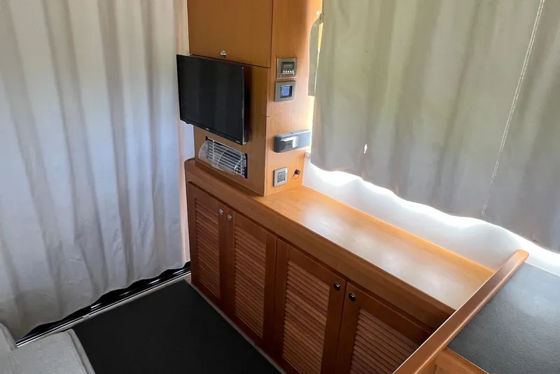 Slide: The Image of Interior of 2020 Beneteau Swift Trawler 35 with TV and wooden cabinetry. - 10