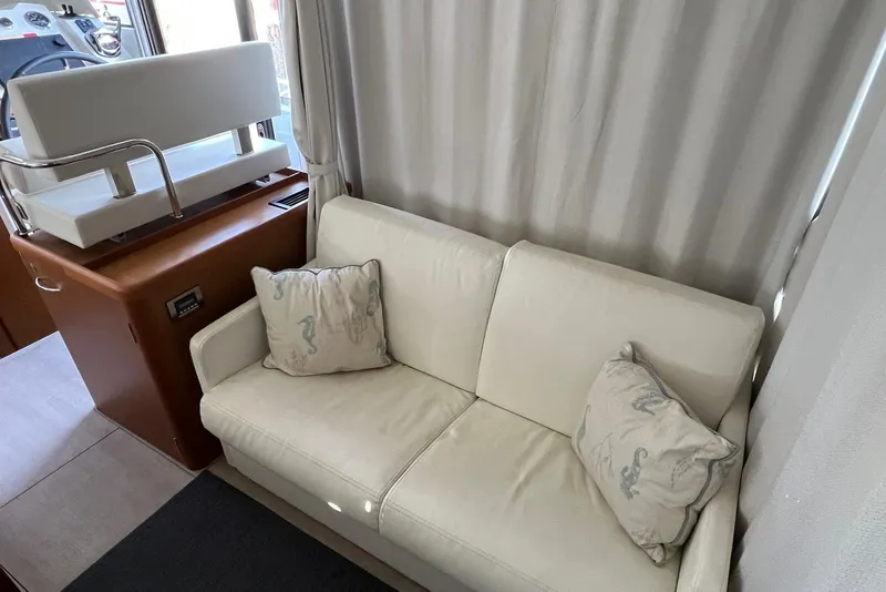Slide: The Image of Interior of 2020 Beneteau Swift Trawler 35 with white sofa and nautical-themed pillows. - 11