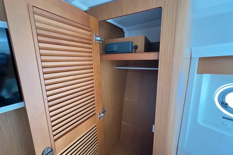Slide: The Image of Interior view of 2020 Beneteau Swift Trawler 35, featuring a wooden closet and porthole. - 15