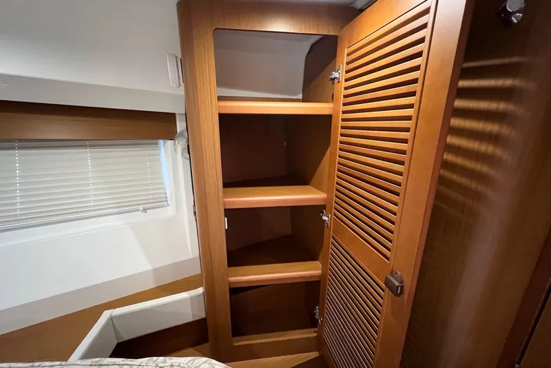 Slide: The Image of 2020 Beneteau Swift Trawler 35 interior with wooden shelving and window blinds. - 17