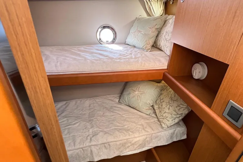Slide: The Image of Cozy bunk beds in 2020 Beneteau Swift Trawler 35 cabin with porthole and wooden finish. - 18