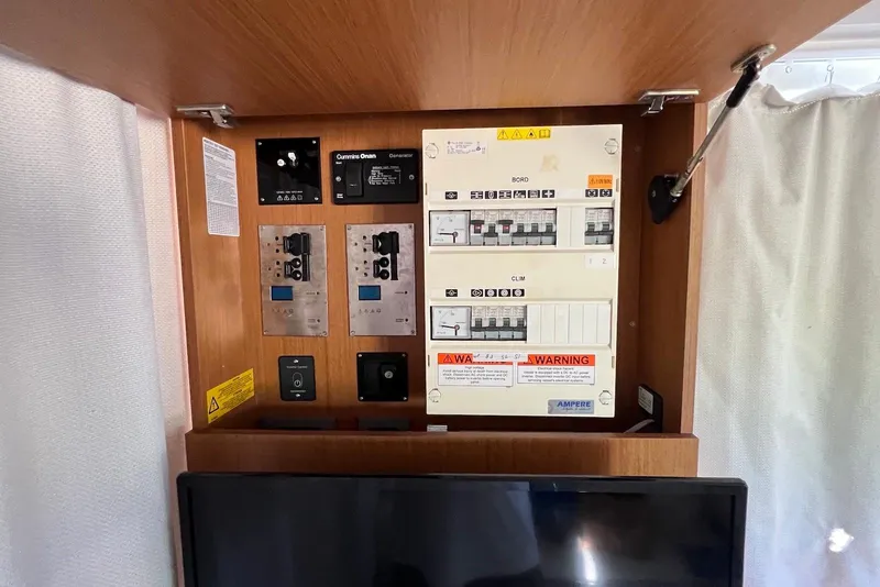 Slide: The Image of Electrical panel inside 2020 Beneteau Swift Trawler 35, featuring Cummins Onan generator controls. - 21