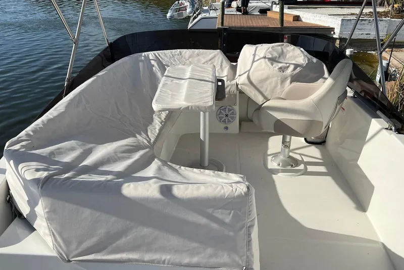 Slide: The Image of 2020 Beneteau Swift Trawler 35 helm with seating, steering wheel, and navigation equipment. - 2