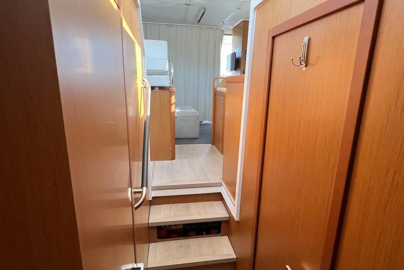 Slide: The Image of Beneteau Swift Trawler 35, 2020 model, featuring foldable deck seating by the water. - 5