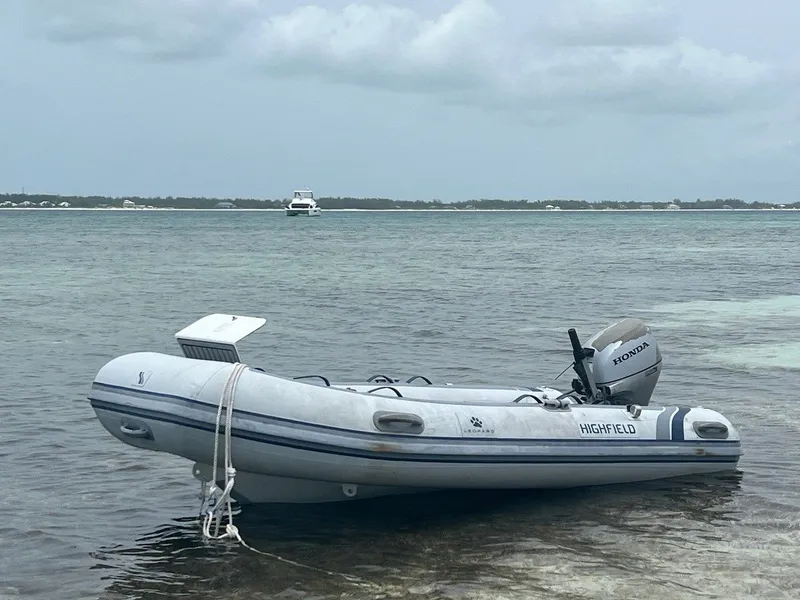 Slide: The Image of Inflatable boat with Honda motor on shore, Leopard 43 PC in background. - 38