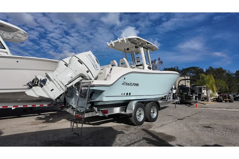 Slide: The Image of 2026 Sailfish 252 CC boat on trailer with Suzuki outboard motor, parked outdoors. - 3